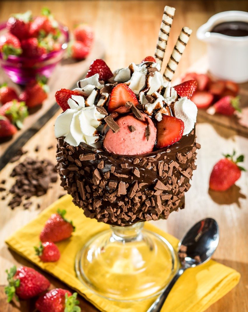 Taça Primo Amore coberta de chocolate e raspas, com chantilly e morangos frescos